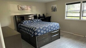 A bedroom with a bed, dresser, desk, and window. - Home away from home (Indiana)