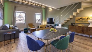 A modern living room with a dining area, a staircase, and a TV. - Gorgeous apartment with city views! Up to 8! (Firenze)