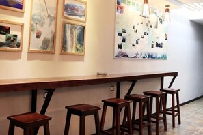 A bar area with wooden stools and a long counter. - Xi'an Inn (Zhangjiajie Zixia Temple) (Zhangjiajie)