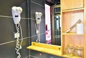 A bathroom with two hair dryers mounted on the wall, a mirror, and a wooden shelf with jars. - Xi'an Inn (Zhangjiajie Zixia Temple) (Zhangjiajie)