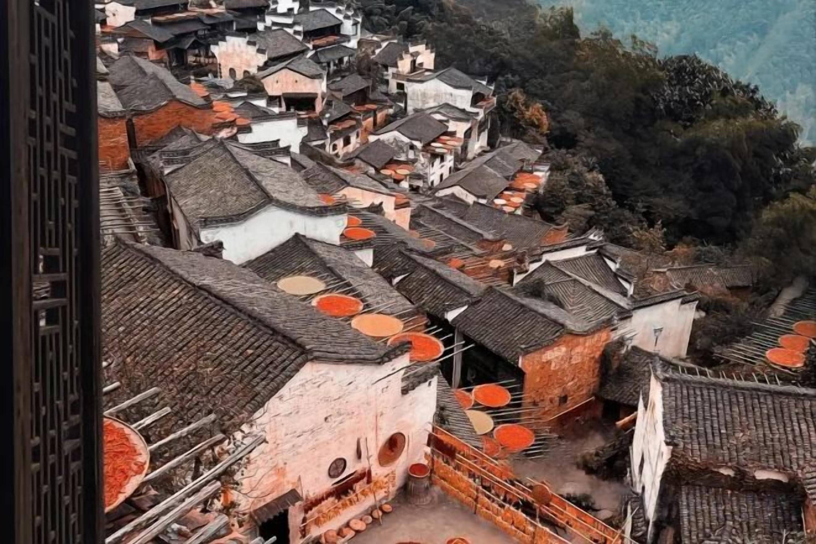 A traditional village with closely packed buildings, some with circular windows and orange decorations.