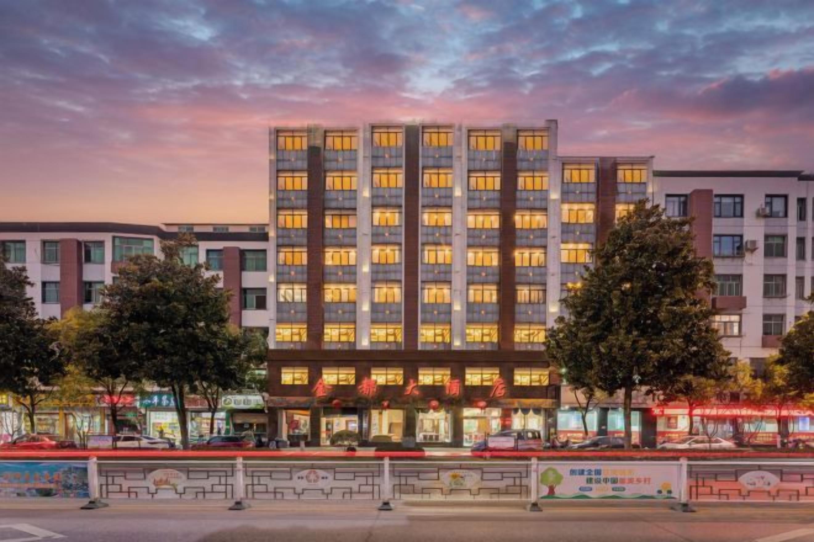 A multi-story hotel with a modern facade, large windows, and a well-lit entrance.