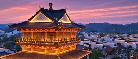 A traditional multi-tiered building with a prominent roof, surrounded by modern structures.