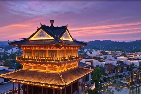 A traditional multi-tiered building with a prominent roof, surrounded by modern structures.