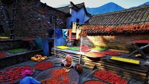 A traditional market with various food items displayed on wooden tables and hanging racks. - Jindu Hotel (Wuyuan)