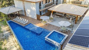 Une piscine sur le toit, dotée d’une terrasse en bois, d’un espace salon extérieur et de panneaux solaires.