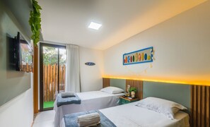 Una habitación de hotel con dos camas, un televisor, una planta y una obra de arte en la pared.