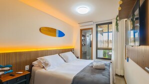 Une chambre d’hôtel avec un lit, une table de chevet, un miroir et une fenêtre avec des rideaux.