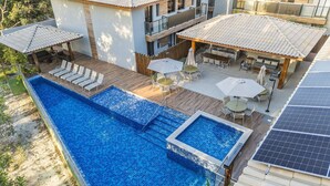 Una piscina sul tetto con un pontile in legno, posti a sedere all'aperto e pannelli solari.