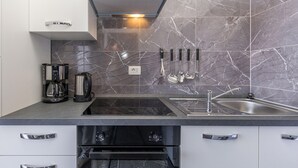 Una cucina moderna con piano cottura integrato, lavello e macchina da caffè.