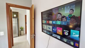 Un téléviseur fixé au mur, affichant différentes applications de diffusion en continu.