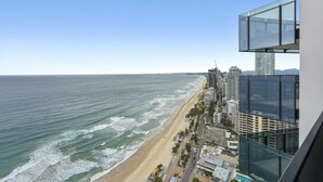 A coastal cityscape with a beach, high-rise buildings, and a clear sky.