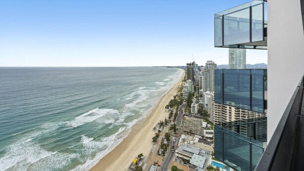 Un paisaje urbano costero con playa, edificios altos y cielo despejado.