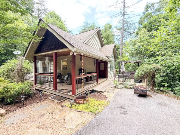 A house with a porch, outdoor seating, and a fire pit.