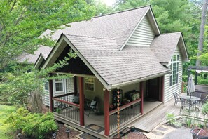 A house with a porch, a deck, and a small garden area.