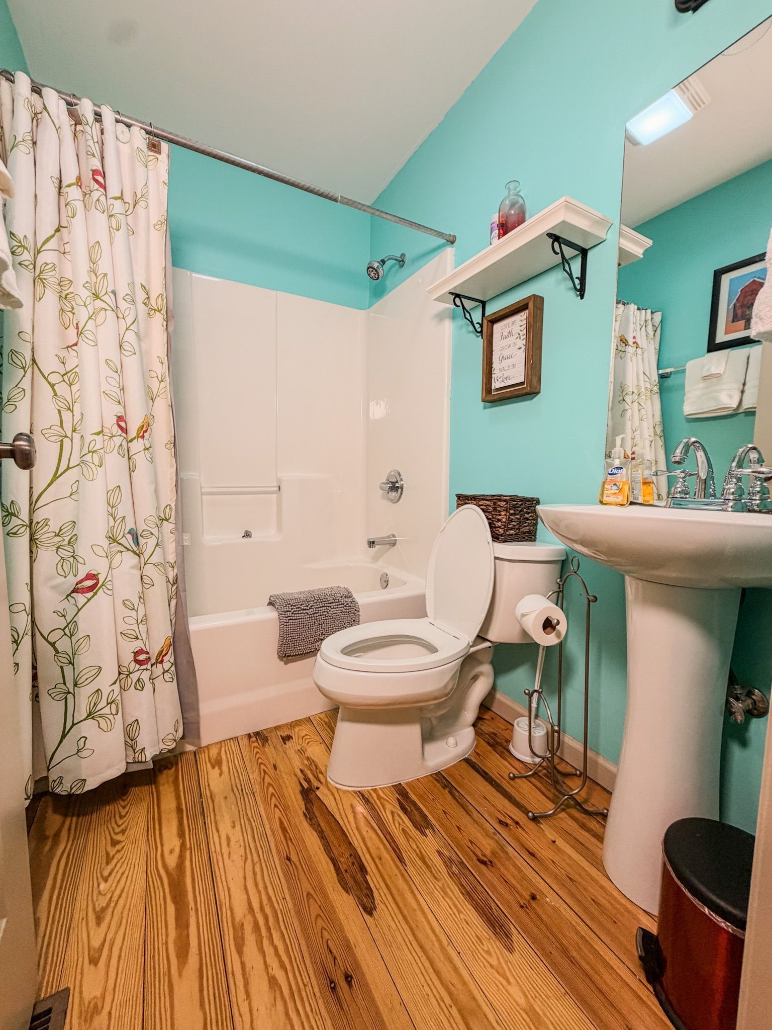 A bathroom with a toilet, shower, and sink.