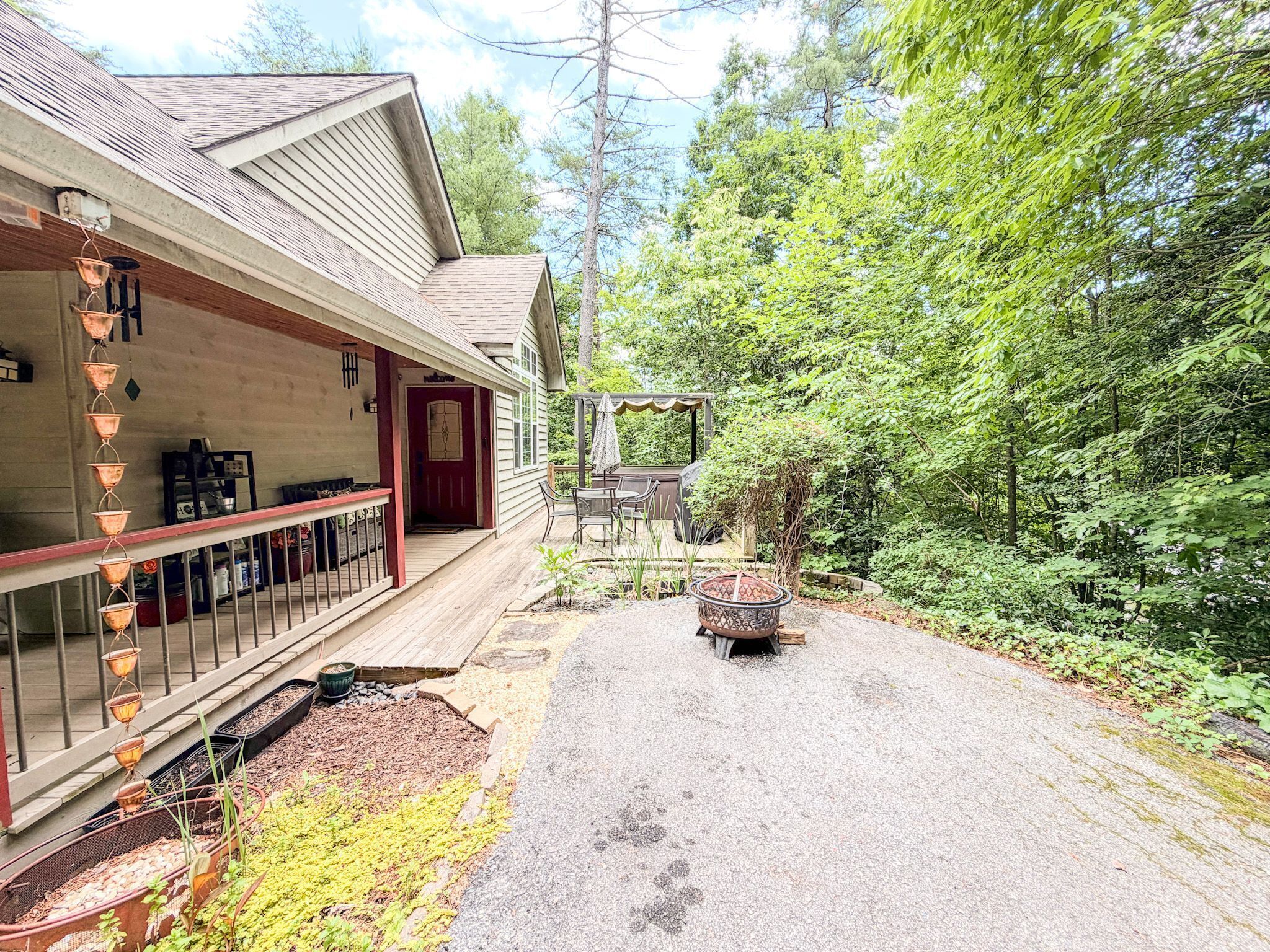 Une maison avec un porche, un espace salon extérieur et un jardin.