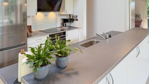A modern kitchen with white cabinets, stainless steel appliances, and a grey countertop. - Beautiful home in Ebeltoft with WiFi (Ebeltoft)
