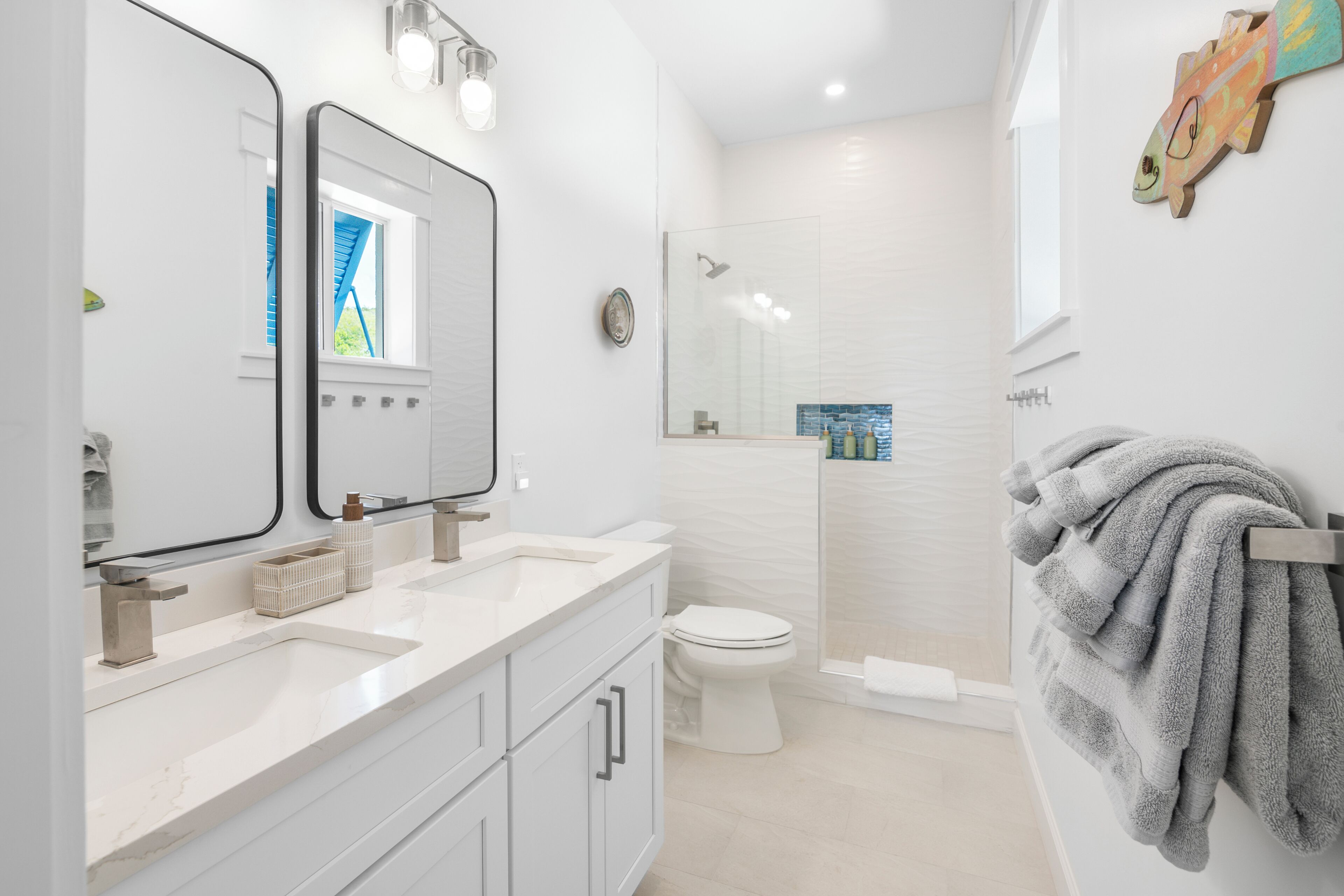 Un baño moderno con lavamanos doble, inodoro y zona de ducha.