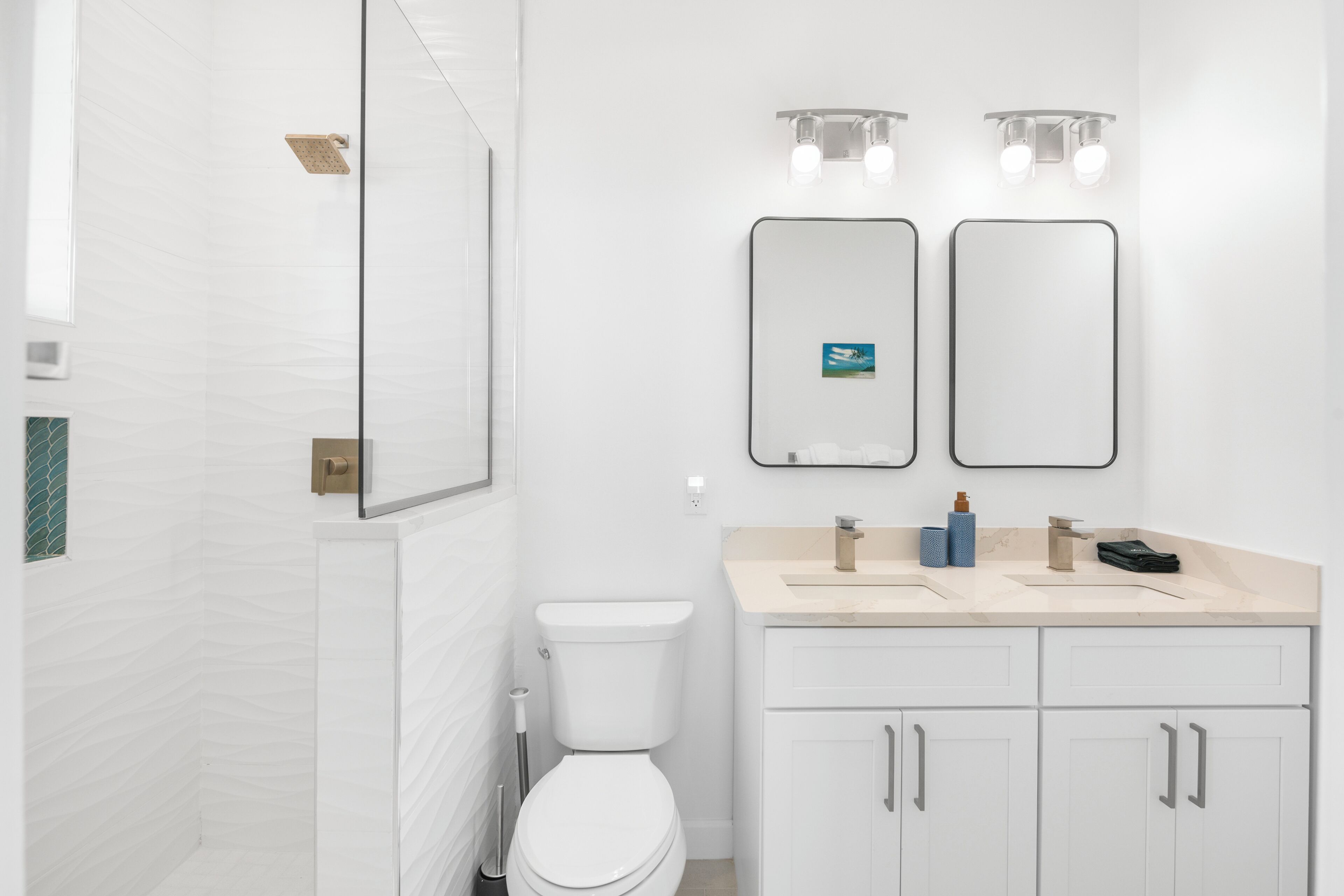 Ein modernes Badezimmer mit Toilette, Dusche und Waschbecken mit Spiegel darüber.