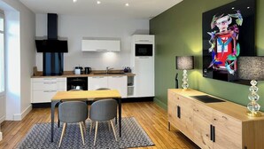 Eine moderne Küche mit weißen Schränken, einem Holztisch und einem schwarz-weißen Teppich.
