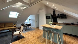A loft-style apartment with a kitchen, dining area, and living space.