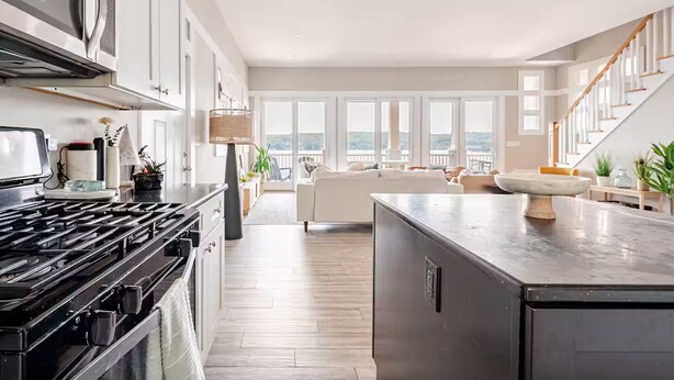 Cocina moderna con una isla grande, electrodomésticos integrados y vista al área de estar.