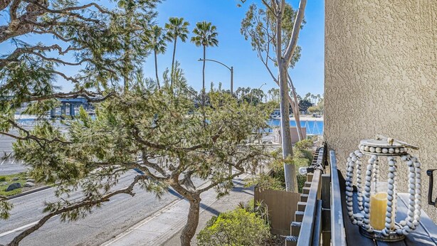 Un balcone con vista sulla spiaggia, una strada e un edificio sullo sfondo.