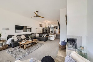 Una sala de estar moderna con sofá, mesa de centro y chimenea.
