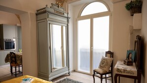 A room with a dining table, a cabinet, a chair, and a large window with a view. - A Casa di Marilù - Lanciano (Lanciano)