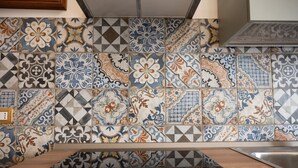 A kitchen with a variety of patterned tiles on the backsplash and a wooden countertop. - A Casa di Marilù - Lanciano (Lanciano)