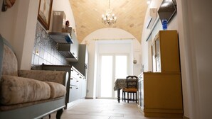 A narrow hallway with a sofa, a dining table with chairs, and a refrigerator. - A Casa di Marilù - Lanciano (Lanciano)