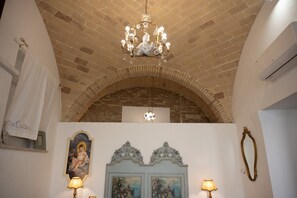 A room with a brick ceiling, a chandelier, a painting, and two lamps. - A Casa di Marilù - Lanciano (Lanciano)