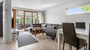 Una sala moderna con un sofá, una mesa de centro y un comedor con una mesa y sillas.