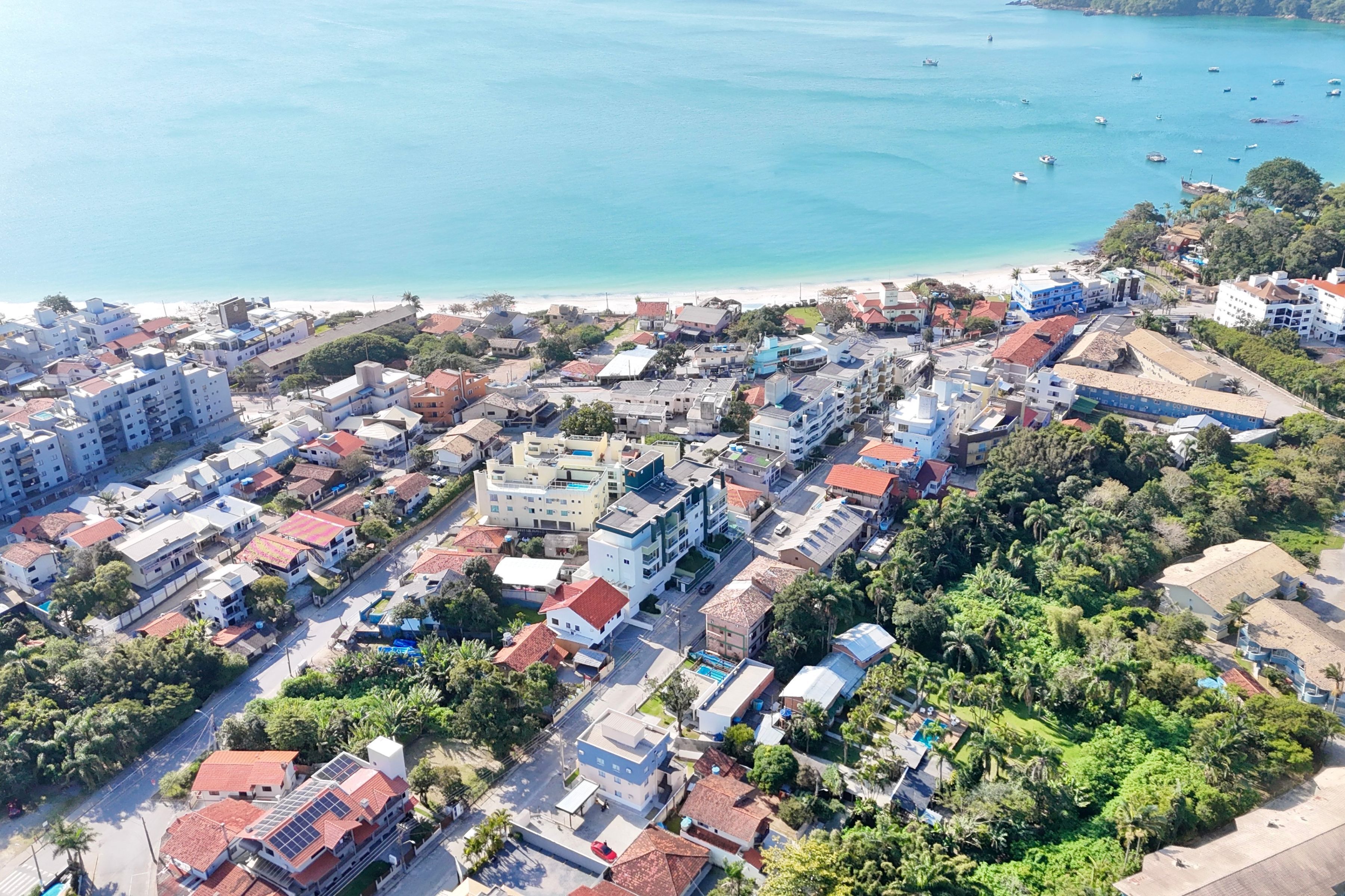 An aerial view of a coastal town with buildings, roads, and a beach.