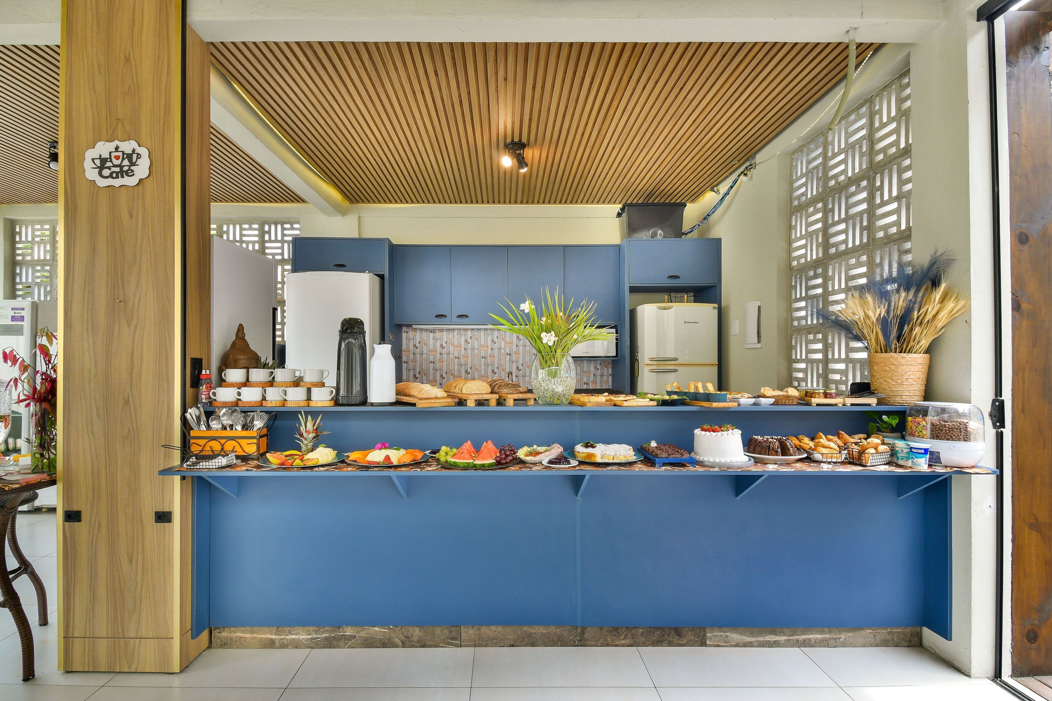 Een buffetgedeelte met diverse soorten eten, een houten plafond en een blauw aanrecht.