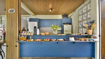 A buffet area with a variety of food items, a wooden ceiling, and a blue counter.