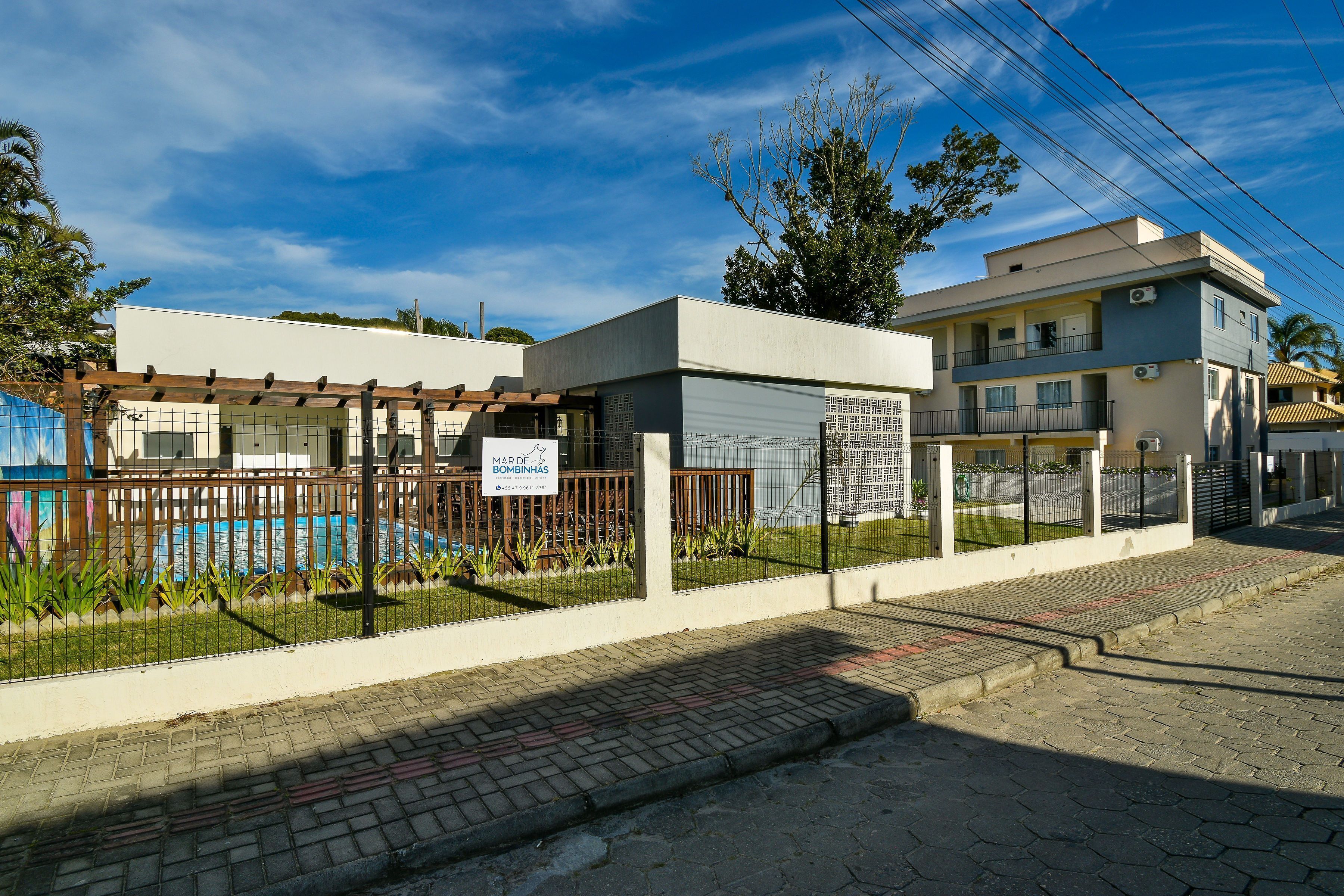 Propriedade murada com piscina, área cercada e um edifício com placa.