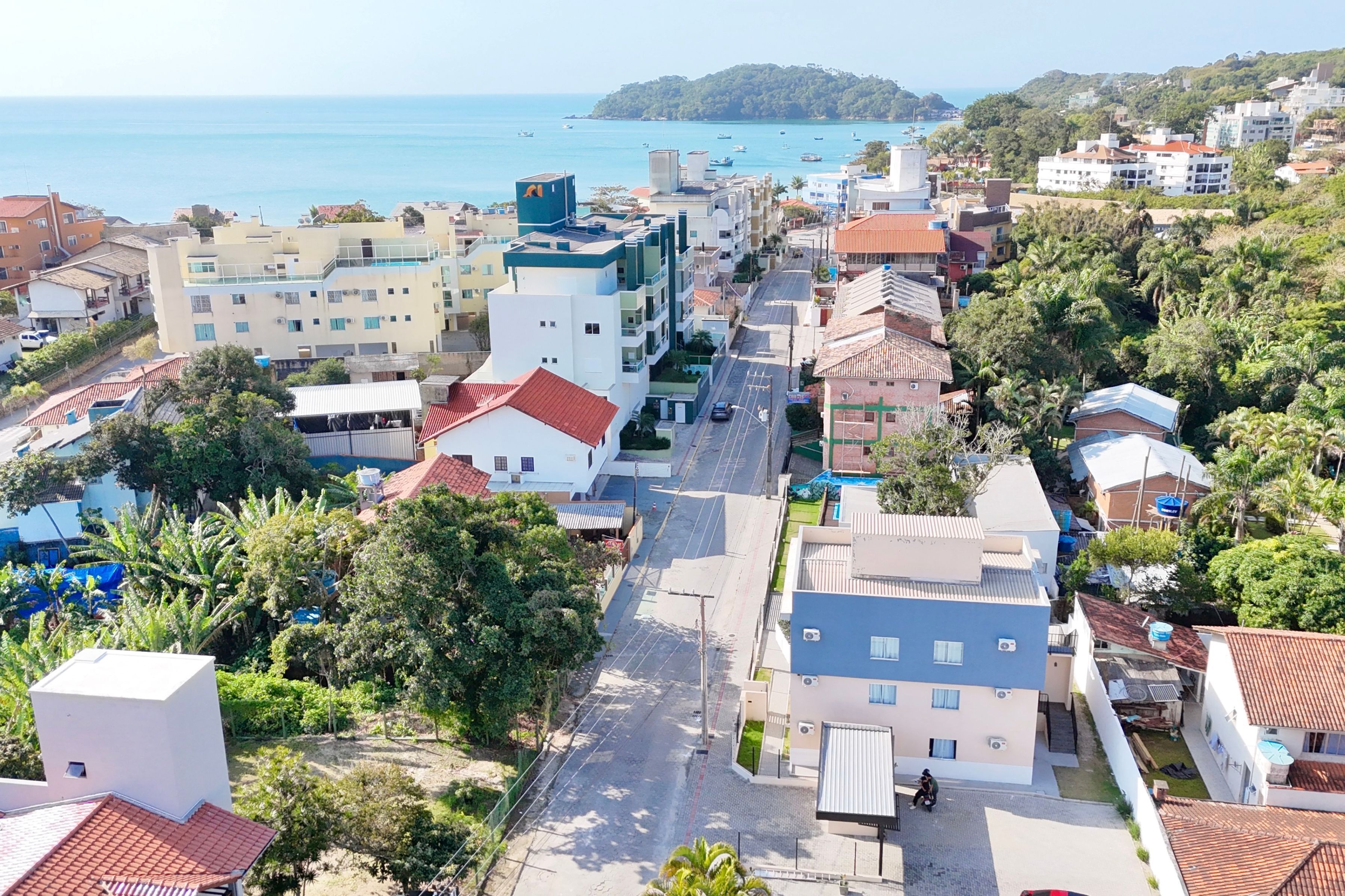 A coastal town with a mix of residential and commercial buildings, a main road, and a view of the sea.