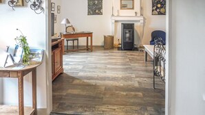 A spacious room with a fireplace, wooden flooring, and a desk with a lamp. - LARGETEAU astronomer's house (Mouilleron Saint Germa)