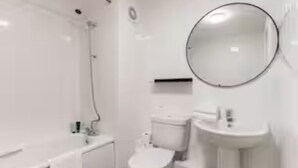 A bathroom with a bathtub, toilet, and sink.