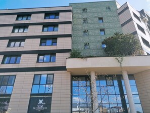 Een meerlaags gebouw met een moderne gevel, grote ramen en een zichtbaar logo in het lagere deel van de gevel.