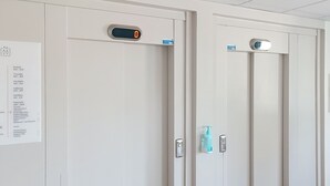 Un ascenseur d’hôtel doté d’un écran numérique et d’un panneau indiquant les numéros des chambres et les équipements disponibles.