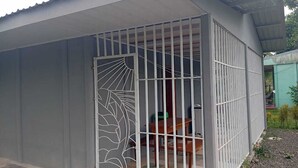 Un edificio con una verja metálica y una mesa en su interior.