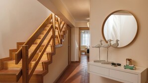 A staircase with wooden railings and a white console table with decorative items.