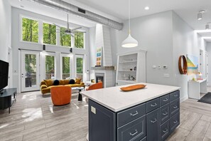 A modern kitchen with a central island, built-in cabinets, and a dining area with a sofa and coffee table.
