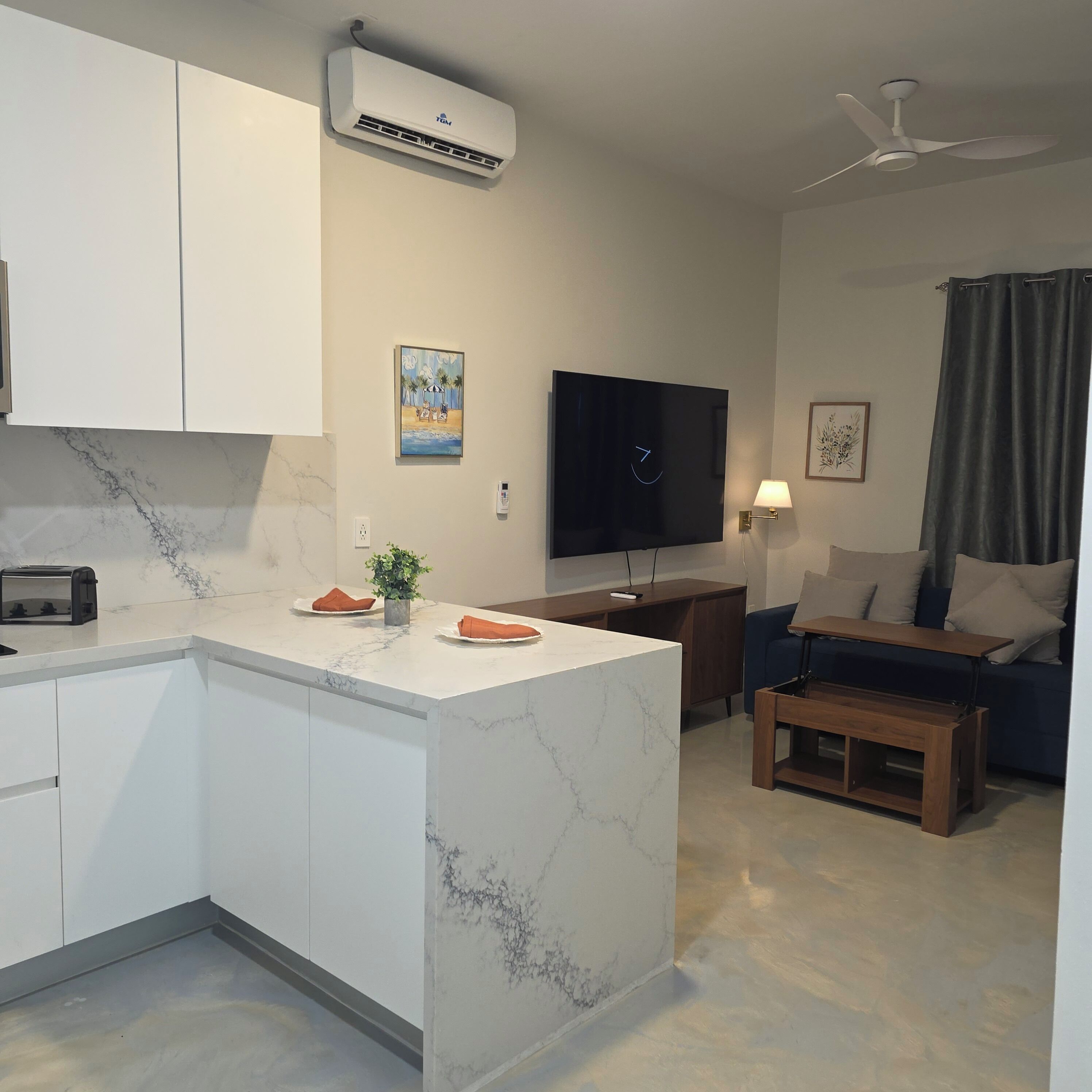 Una cucina moderna con un piano di lavoro in marmo, forno integrato e ventilatore a soffitto.