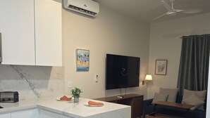 A modern kitchen with a marble countertop, a built-in oven, and a ceiling fan. - Chic 1-bedroom luxury suite in fabulous Nassau. Comfort. Class. Convenience. (Nassau)