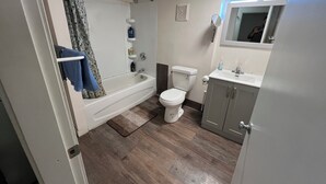 A bathroom with a bathtub, toilet, and sink.