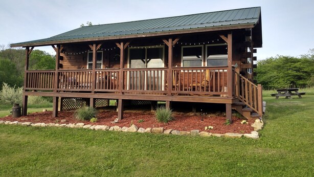 A wooden cabin with a porch, deck, and outdoor seating area. - Private cabin on the beautiful Kickapoo River Valley near Wildcat Mountain Park. (Ontario)